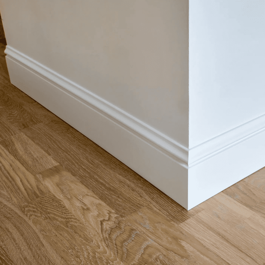 Rodapié blanco decorativo en esquina con suelo de madera, diseño moderno para pared
