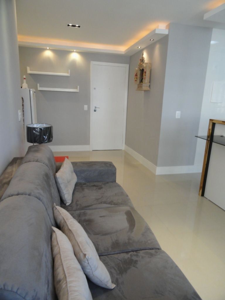 Sala moderna con sofá gris, paredes grises, molduras decorativas y rodapié blanco.