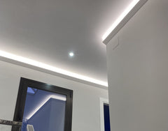 Moldura decorativa en techo blanco con iluminación LED indirecta en interior moderno
