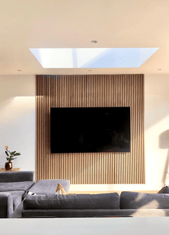 Sala moderna con pared decorativa de lamas de madera, televisor y sofá gris