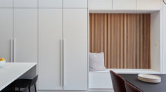 Panel decorativo de lamas de madera en pared moderna con banco blanco y cojín