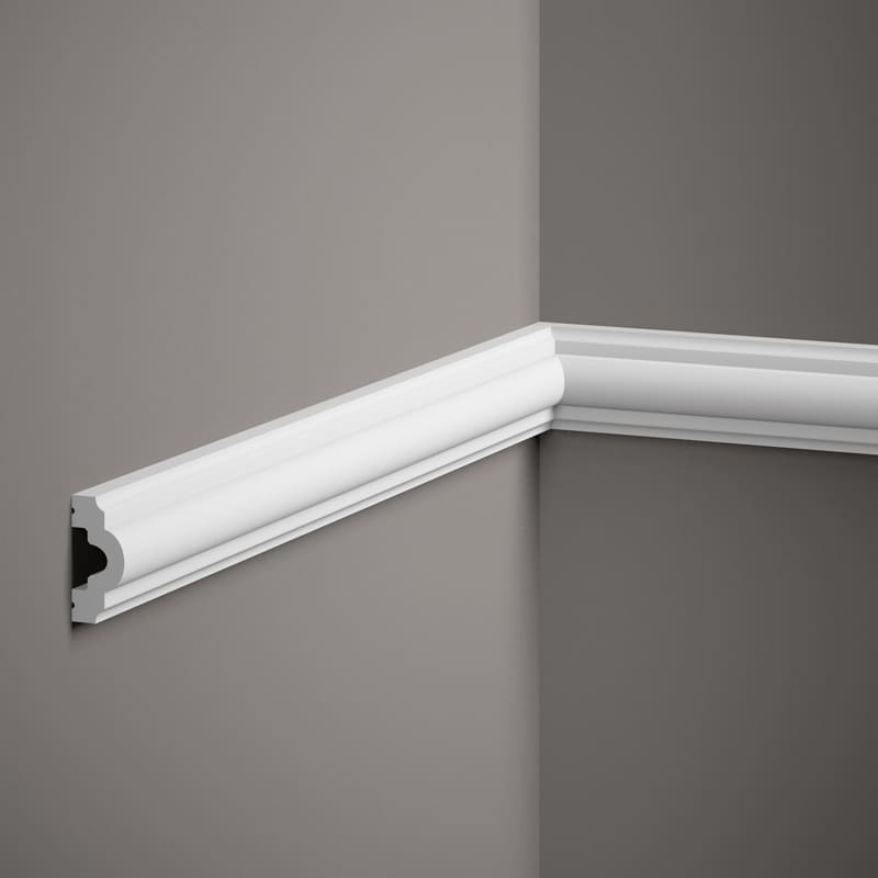 Moldura decorativa blanca instalada en esquina de pared gris, diseño clásico para interiores