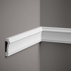 Moldura decorativa blanca instalada en esquina de pared gris, diseño clásico de interior.