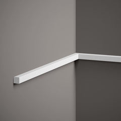Moldura decorativa blanca de perfil recto instalada en esquina de pared gris