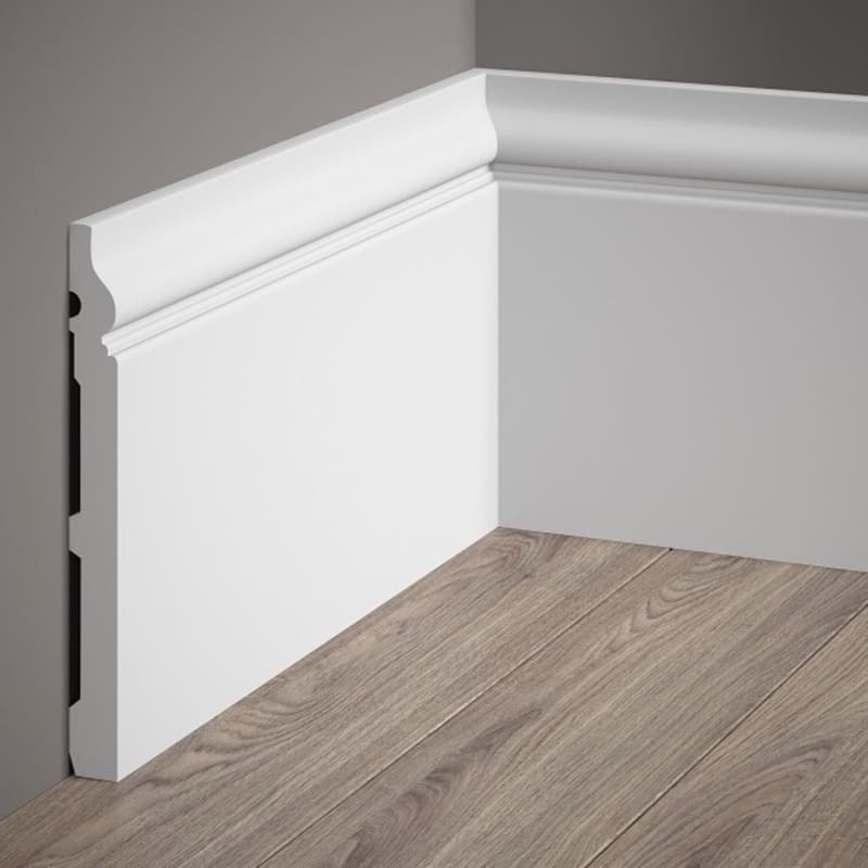 Rodapié blanco decorativo de alta calidad instalado en pared gris y suelo de madera clara.