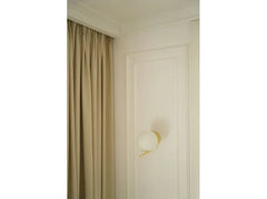 Moldura decorativa blanca en pared con aplique dorado y cortina beige