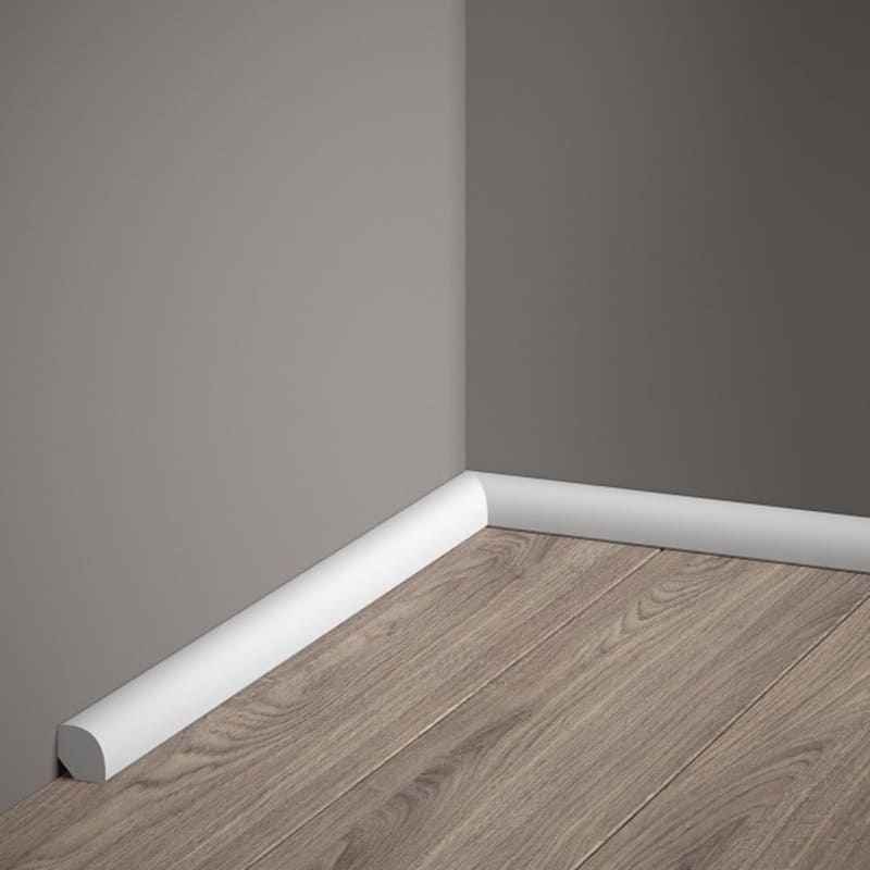 Rodapié blanco moderno en esquina con suelo laminado y pared gris