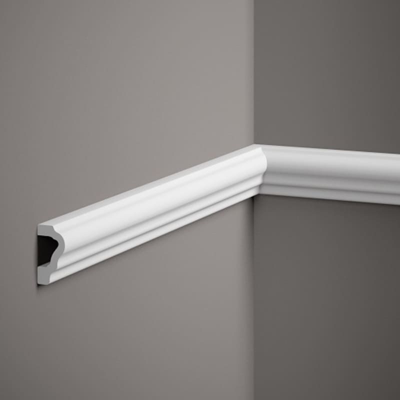 Moldura decorativa blanca instalada en esquina de pared gris, diseño clásico de interiores