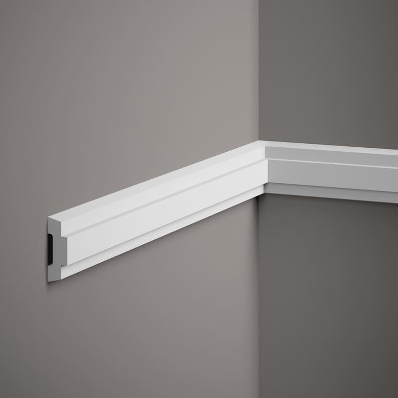 Moldura decorativa blanca instalada en pared gris, ideal para acabado de interiores modernos.