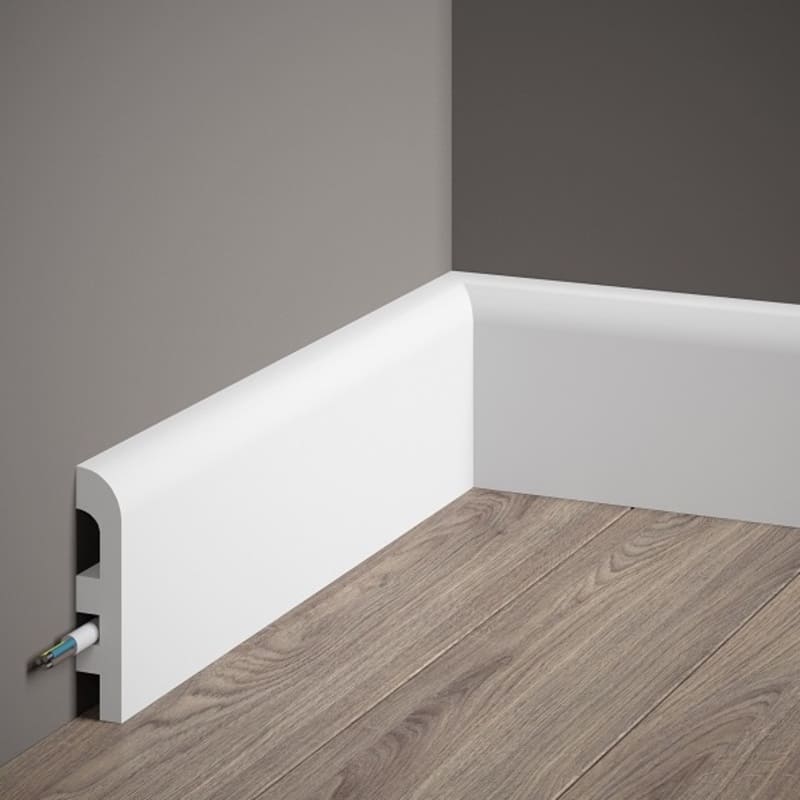 Rodapié blanco moderno con canal para cables sobre suelo de madera y pared gris