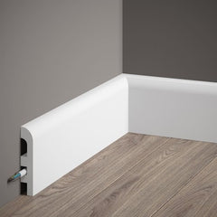 Rodapié blanco moderno con canal para cables sobre suelo de madera y pared gris