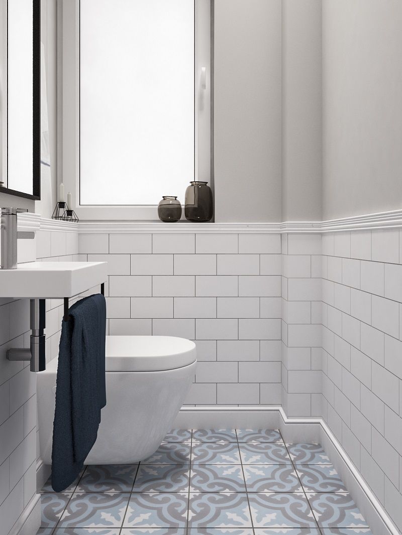 Baño moderno con molduras decorativas blancas, azulejos rectangulares y suelo hidráulico azul gris.