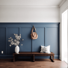 Pared azul con molduras decorativas, banco de madera y rodapié en entrada luminosa