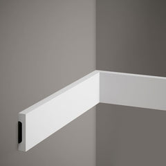 Moldura decorativa blanca moderna instalada en esquina de pared gris, diseño minimalista.