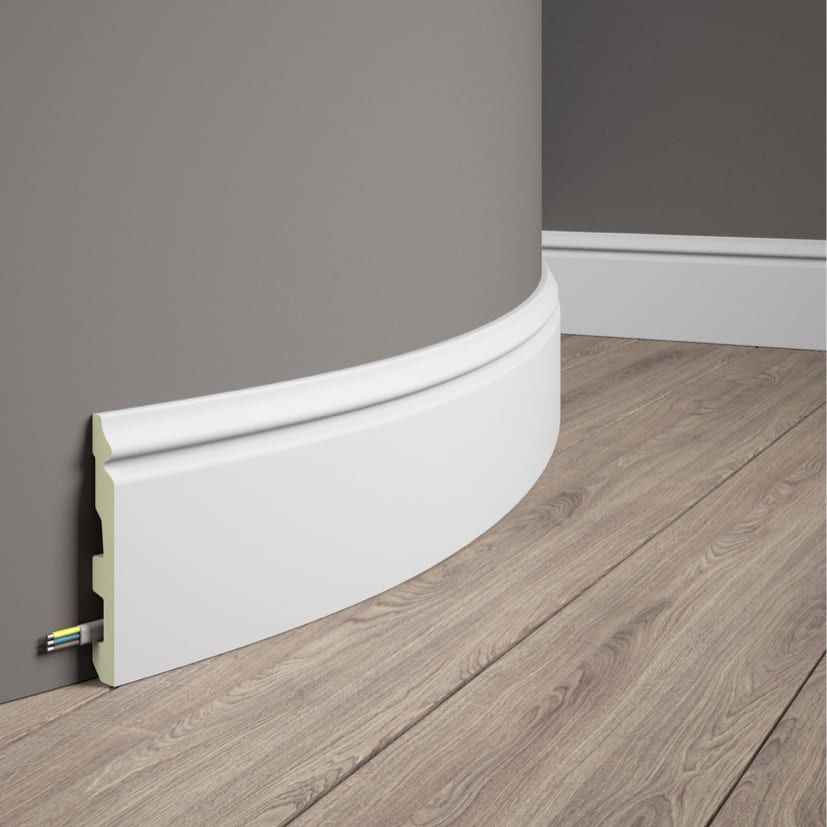 Rodapié flexible blanco para pared curva, ocultando cables, ideal para suelos de madera.
