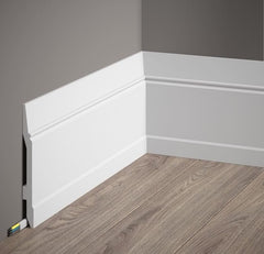 Rodapié blanco decorativo instalado en esquina de pared gris con suelo de madera