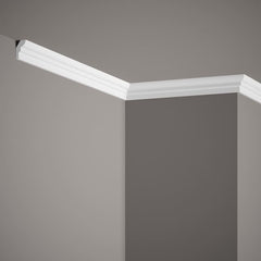 Moldura decorativa blanca instalada en esquina de techo y pared gris