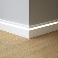 Rodapié blanco decorativo con luz LED en esquina de pared y suelo de madera clara