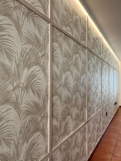 Pared decorativa con molduras blancas y papel tapiz de hojas, iluminación LED superior