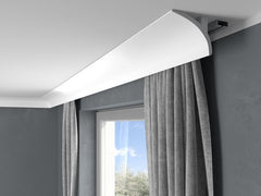Moldura decorativa blanca para techo sobre ventana con cortinas grises, diseño moderno
