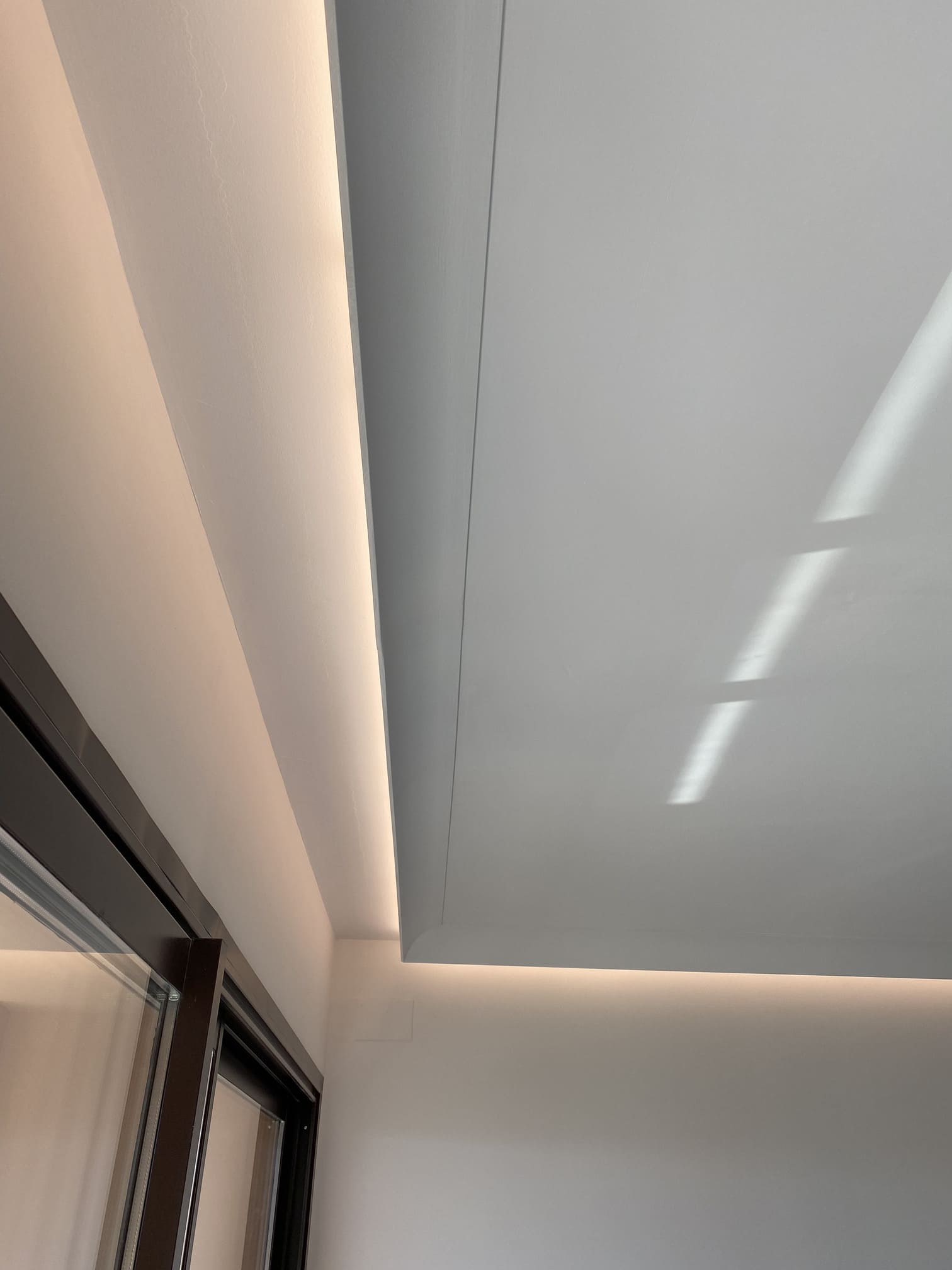 Moldura decorativa moderna en techo con iluminación LED indirecta en habitación minimalista