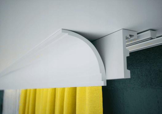 Moldura decorativa blanca de techo para cortina, con acabado moderno y cortina amarilla