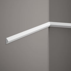 Moldura decorativa blanca instalada en esquina de pared gris, estilo moderno