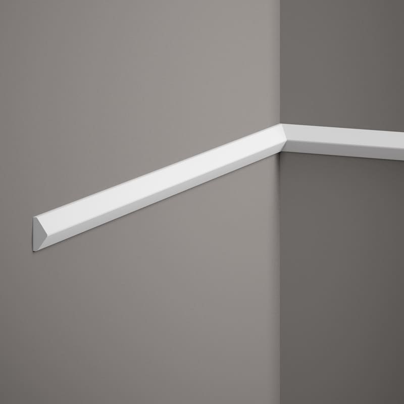 Moldura decorativa blanca instalada en esquina de pared gris, estilo moderno