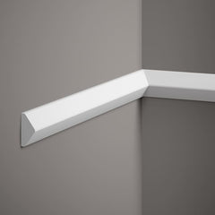 Moldura decorativa blanca moderna instalada en pared gris, ideal para interiores.