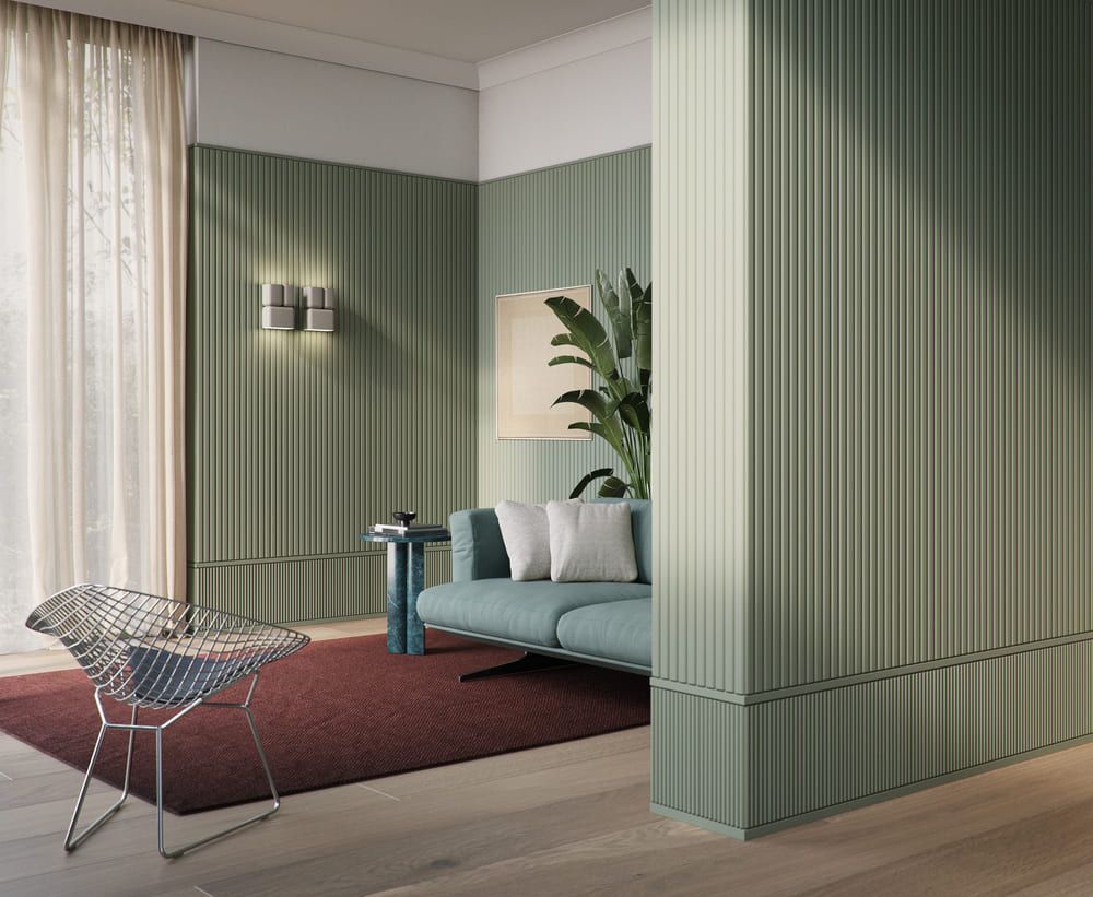 Sala moderna con molduras decorativas verdes, sofá, silla metálica y alfombra roja.