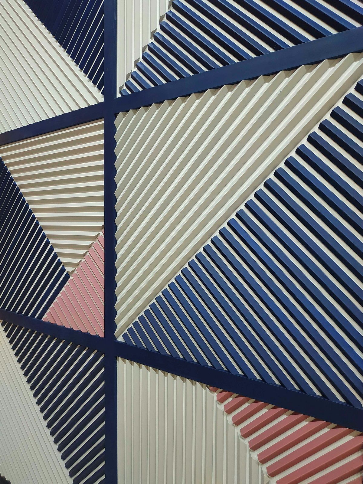 Panel decorativo de molduras geométricas en colores azul, blanco y rosa para paredes modernas.