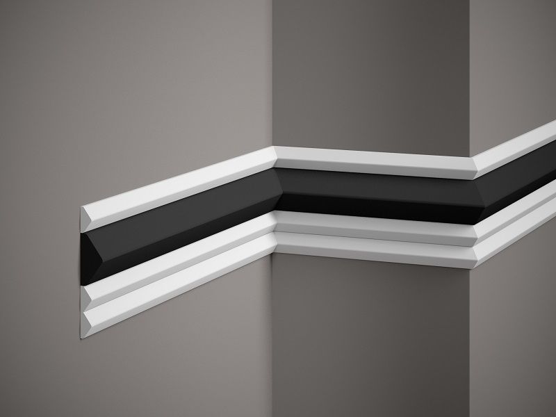 Molduras decorativas blancas y negras instaladas en esquina de pared interior moderna.