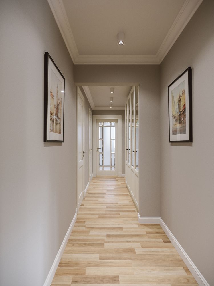 Pasillo moderno con molduras decorativas, rodapiés blancos y suelo de madera clara.